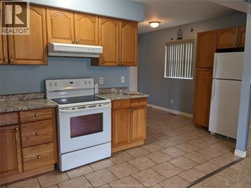 Windsor multi-family for rent - A kitchen with a white stove and wooden cabinets.