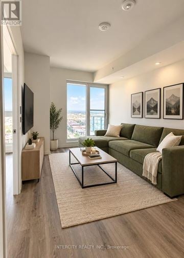 Vaughan (Vaughan Corporate Centre) condo for rent - A living room with a green couch and a flat screen TV mounted on the wall.