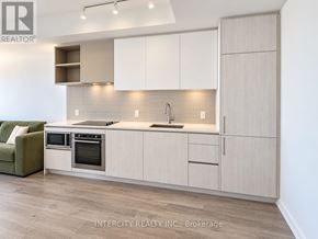 Vaughan (Vaughan Corporate Centre) condo for rent - A modern kitchen with white cabinets and a green sofa.