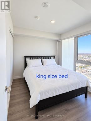 Vaughan (Vaughan Corporate Centre) condo for rent - A bedroom with a king size bed and a view of the city.