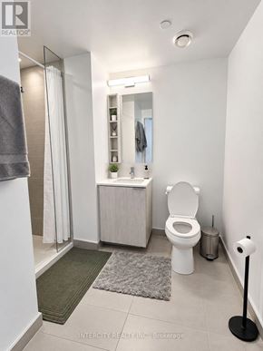 Vaughan (Vaughan Corporate Centre) condo for rent - A white bathroom with a toilet, sink, and mirror.