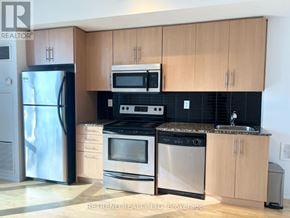 Toronto (Waterfront Communities) condo for rent - A kitchen with wooden cabinets and stainless steel appliances.