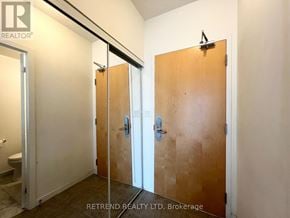 Toronto (Waterfront Communities) condo for rent - A hallway with three doors and a toilet visible in the background.