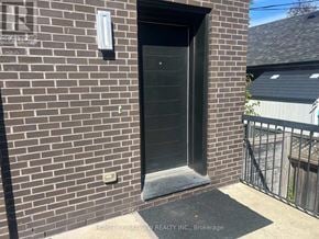 Toronto (East York) triplex for rent - A brick wall with a door and a sign that says "HOMELIFE/BAYVIEW REALTY INC., Brokerage".