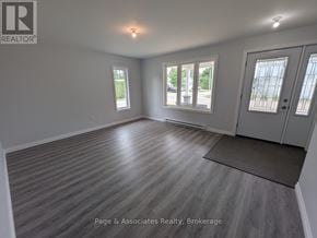 West Nipissing (Sturgeon Falls) apartment for rent - A spacious room with wooden flooring and a large window.