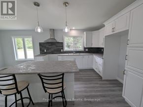 West Nipissing (Sturgeon Falls) apartment for rent - A kitchen with a marble countertop and white cabinets.