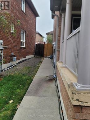 Brampton (Fletcher's Meadow) apartment for rent - A sidewalk runs between a brick house and a white house.