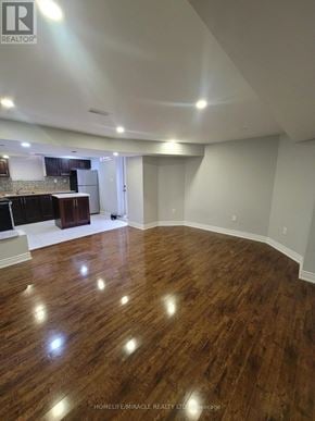 Brampton (Fletcher's Meadow) apartment for rent - A spacious room with wooden flooring and a kitchen area in the background.