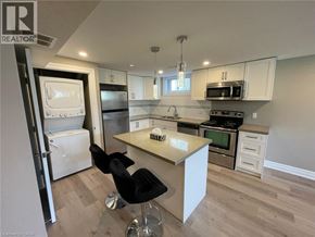Kitchener apartment for rent - A kitchen with a white countertop and black chairs.