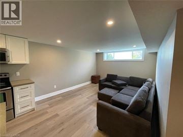 Kitchener apartment for rent - A living room with a brown couch and a window.