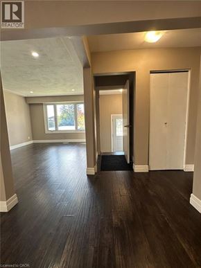 Kitchener apartment for rent - A room with wooden floors and a doorway leading to another room.