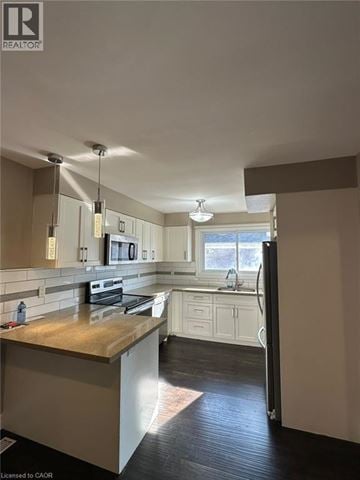 Kitchener apartment for rent - A kitchen with a wooden counter top and white cabinets.