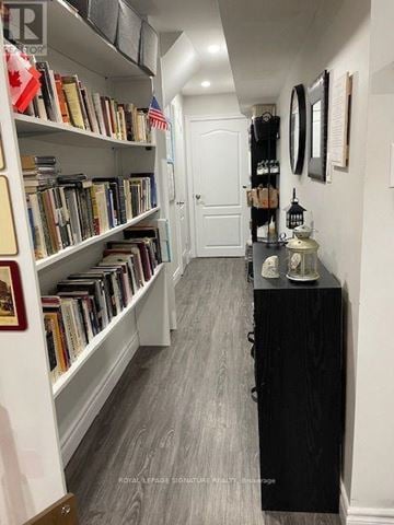 Ajax (Northwest Ajax) apartment for rent - A hallway with a black cabinet and a bookshelf with books and flags.