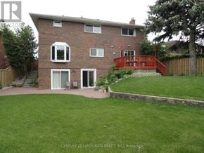 Toronto (L'amoreaux) apartment for rent - A brick house with a red deck and a well-kept lawn.