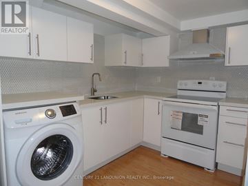 Toronto (L'amoreaux) apartment for rent - A white washing machine is in a kitchen with white cabinets.