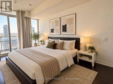Toronto (Church-Yonge Corridor) condo for rent - A bedroom with a large bed and a city view through the window.