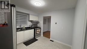 Toronto (Malvern) apartment for rent - A kitchen with white cabinets and a black stove top oven.