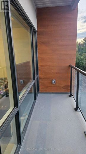 Ottawa multi-family for rent - A balcony with a glass railing and a wooden wall.