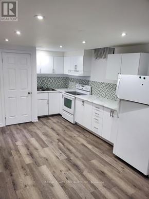 Brampton (Brampton South) apartment for rent - A kitchen with white cabinets and a wooden floor.