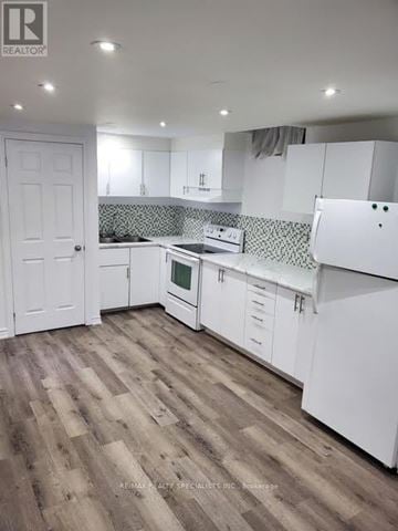 Brampton (Brampton South) apartment for rent - A kitchen with white cabinets and a wooden floor.