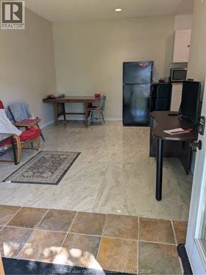 Tecumseh apartment for rent - A kitchen area with a table, chairs, and a refrigerator.