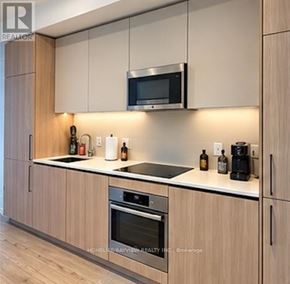 Toronto (Waterfront Communities) condo for rent - A modern kitchen with wooden cabinets and stainless steel appliances.
