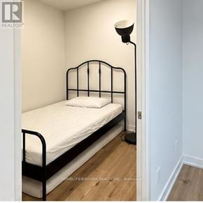 Toronto (Waterfront Communities) condo for rent - A bed with a white sheet and a black metal frame.
