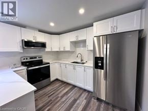 Kitchener apartment for rent - A kitchen with white cabinets and a stainless steel refrigerator.
