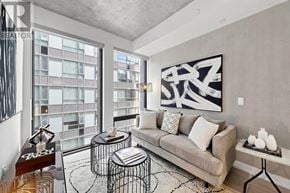 Toronto (Moss Park) condo for rent - A living room with a couch, a coffee table, and a large window.