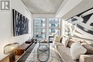 Toronto (Moss Park) condo for rent - A living room with a large window and a painting on the wall.