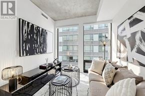 Toronto (Moss Park) condo for rent - A modern living room with a large window and a painting on the wall.