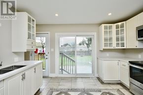 Barrie (Wellington) apartment for rent - A kitchen with white cabinets and a black stove top oven.