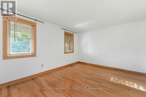 Oshawa (Samac) apartment for rent - A room with wooden flooring and two windows with blinds.