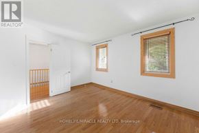 Oshawa (Samac) apartment for rent - A room with wooden floors and white walls, with a door and a window.
