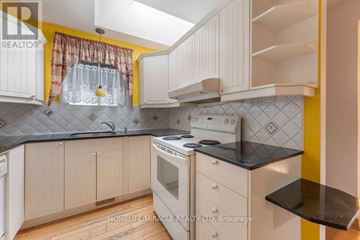 Oshawa (Samac) apartment for rent - A kitchen with white cabinets and a black countertop.