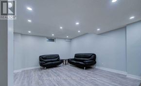 Toronto (Highland Creek) apartment for rent - Two black leather sofas in a room with white walls and wooden flooring.