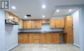 Toronto (Highland Creek) apartment for rent - A kitchen with wooden cabinets and a marble floor.