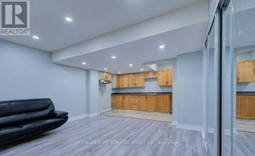 Toronto (Highland Creek) apartment for rent - A living room with a black sofa and wooden cabinets.