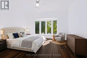 Aurora (Bayview Wellington) apartment for rent - A bedroom with a large bed, a chair, and a ceiling fan.