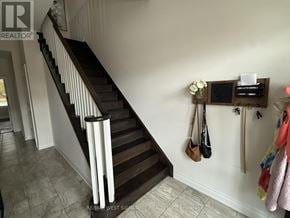 King (Nobleton) townhouse for rent - A hallway with a staircase and a coat rack with several coats hanging.