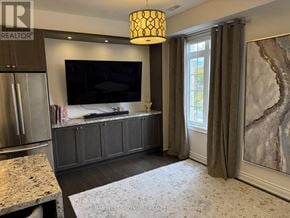 King (Nobleton) townhouse for rent - A modern kitchen with a refrigerator, a television, and a rug on the floor.