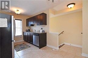 Brampton (Northwest Brampton) townhouse for rent - A kitchen with black cabinets and a refrigerator.