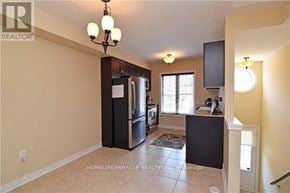 Brampton (Northwest Brampton) townhouse for rent - A kitchen with a black fridge and a black counter top.