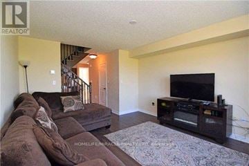 Brampton (Northwest Brampton) townhouse for rent - A living room with a brown couch and a television.