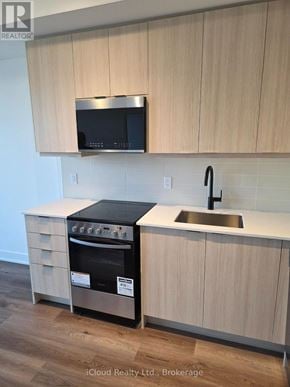Milton (Tm Timberlea) condo for rent - A kitchen with a stove and microwave above it.