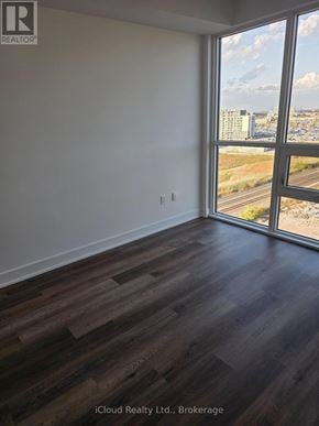 Milton (Tm Timberlea) condo for rent - A room with wooden flooring and a large window overlooking a highway.