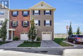 London North (North I) townhouse for rent - A two-story residential building with a garage and a driveway in front.