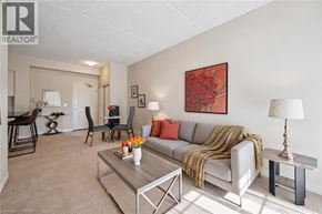Guelph condo for rent - A living room with a grey couch, a coffee table, and a painting on the wall.