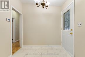 Tillsonburg apartment for rent - A hallway with a white door and a chandelier.