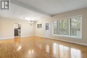 Tillsonburg apartment for rent - A spacious room with wooden flooring and a large window with blinds.
